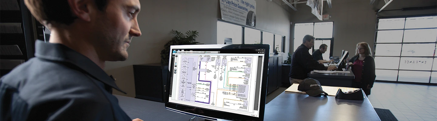 Automotive technician in shop lobby with customers overlooking  ShopKey Shop Repair Information and Management