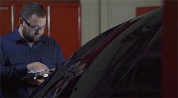 Automotive Associate using a Snap-on diagnostic scan tool behind a Volkswagen Golf door pannel